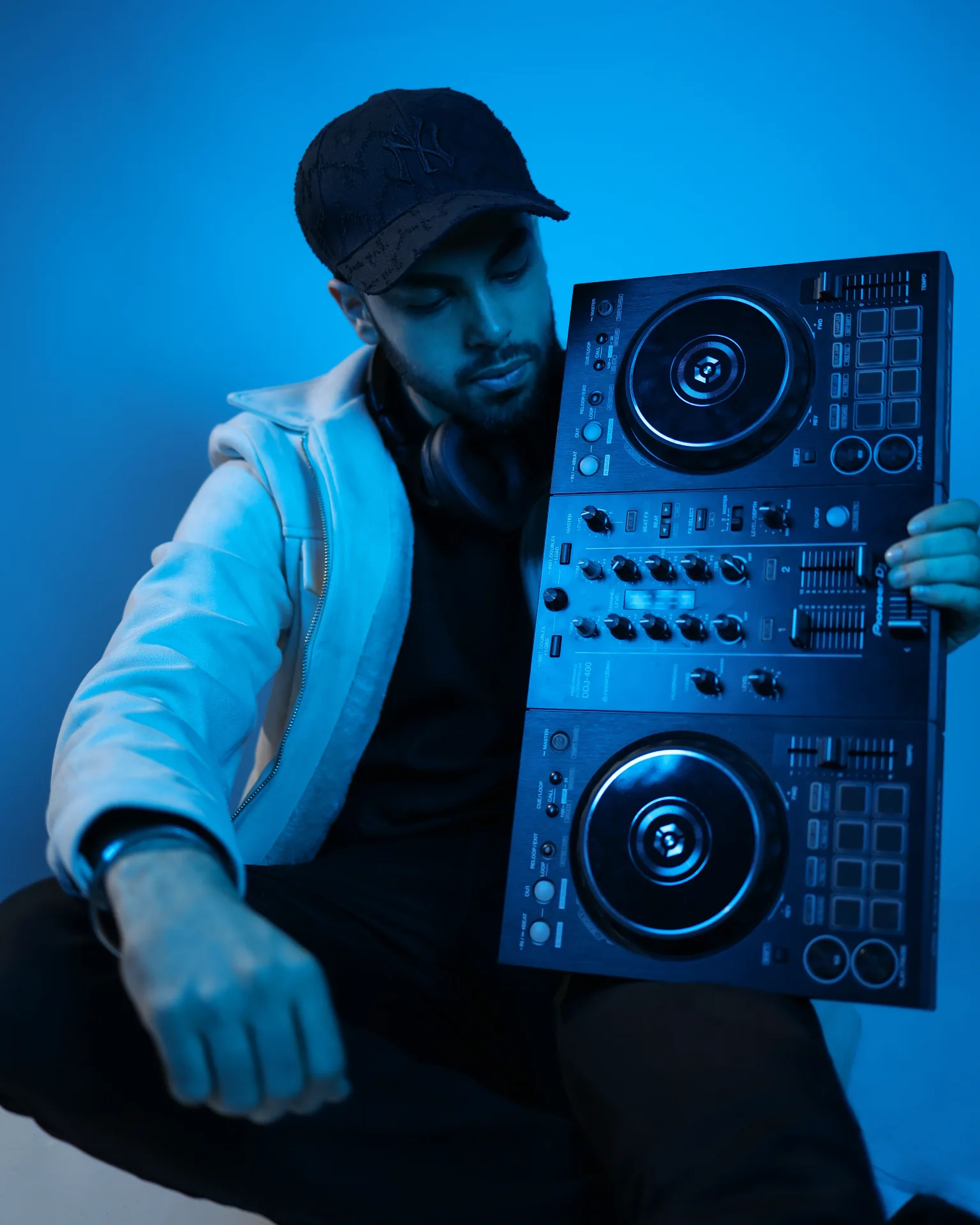Kaydrop in blue studio lighting holding a Pioneer DDJ-400 controller.
