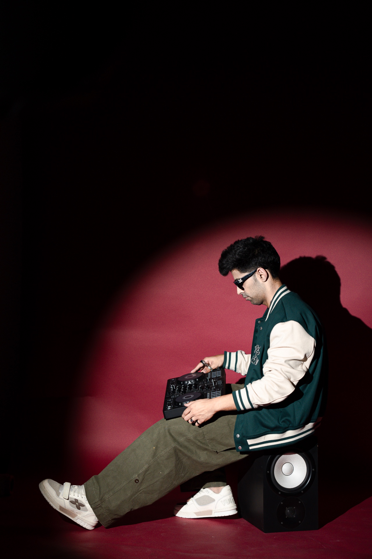 Bahul mixing on his controller seated over a studio monitor.