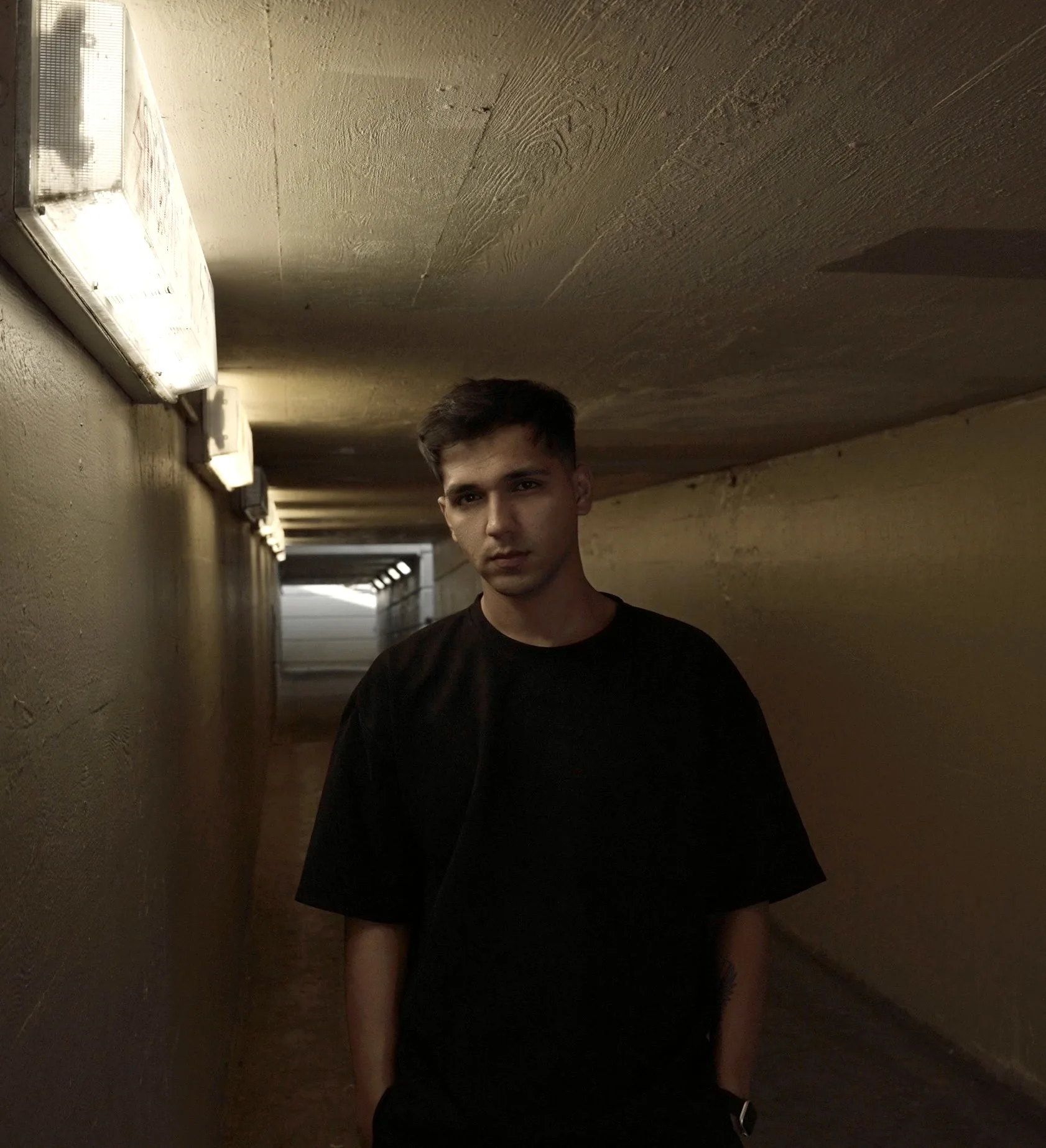 Exbow in a warm-lit underpass tunnel — moody editorial shot.