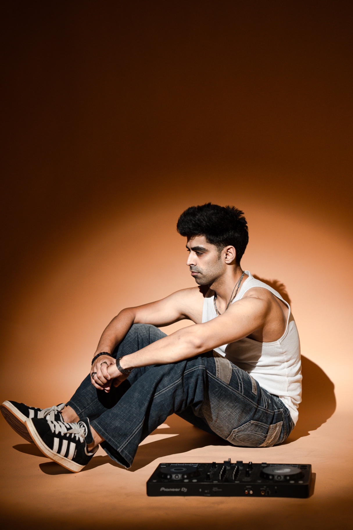 Bahul in a warm-lit editorial portrait with his Pioneer DJ controller.