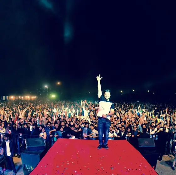 SRV on stage in front of a large festival crowd.